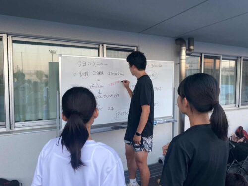 Run for the Future 墨田スクールの定期スクール 中学生以上の練習の様子です。三枝コーチがホワイトボードに今日の練習メニューを書いています。